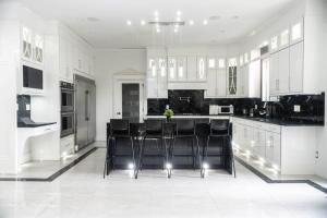 een keuken met zwarte stoelen en witte kasten bij Spacious Luxury Home With Amazing Views in Surrey