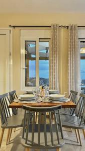 comedor con mesa, sillas y ventana en Villa Michael Triopetra Private Villa, Private Swimming Pool, Garden, Panoramic Sunset, en Triopetra