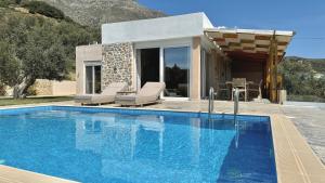 uma villa com uma piscina e uma casa em Villa Michael Triopetra Private Villa, Private Swimming Pool, Garden, Panoramic Sunset em Triopetra