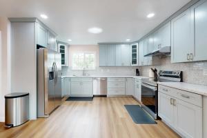 a kitchen with white cabinets and wooden floors at Sunrise Haven in Santa Clara in Santa Clara