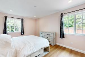 a bedroom with a bed and two windows at Sunrise Haven in Santa Clara in Santa Clara