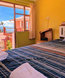 1 dormitorio con cama y ventana con vistas en Amantani sol Andino en Ocosuyo