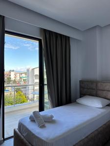 a bedroom with a bed and a large window at Noa Boutique Hotel in Ksamil