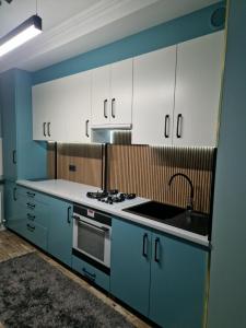 a kitchen with blue and white cabinets and a sink at Apartament Hotel, Chisinau, Botanica, Aeroport in Chişinău