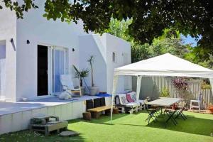 a backyard with a white tent and a table at Villa Loba. Apartamento en casa rural. in Facinas