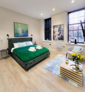 里茲的住宿－Stunning High Spec Apartment in Leeds City Centre，一间带大型绿色床的卧室和一间客厅