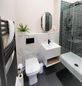 een badkamer met een toilet, een wastafel en een douche bij Lovely and Modern Apartment in Leeds City Centre in Leeds