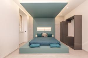 a bedroom with a bed with blue pillows at Le note di Fred Rent Room in Campobasso