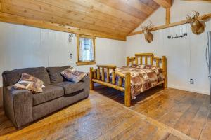 ein Wohnzimmer mit einem Sofa und einem Bett in der Unterkunft Rustic Wellston Cabin with Fire Pits and ATV Trails! in Hamden