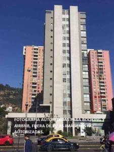 a car parked in front of a tall building at Cómodo departamento Cerca de Metro in Santiago