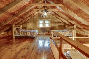 een zolderkamer met een bed en een raam bij Rustic Wellston Cabin with Pond and ATV Trail Access! in Hamden