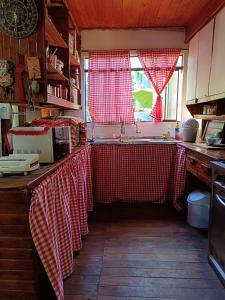 uma cozinha com toalhas de mesa vermelhas e brancas nos balcões em Casa Mágica a orillas del Rio em Puerto Iguazú