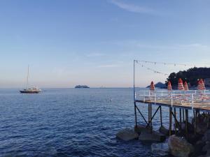 een pier met parasols en een boot in het water bij Il porto di Santa - a un passo da Portofino in Santa Margherita Ligure