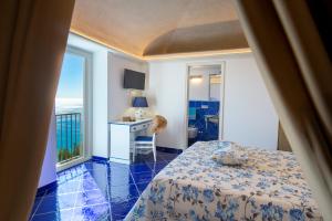 a bedroom with a bed and a desk with a window at Le Contrade by Sosòre Holiday Homes -Amalfi Coast in Furore +140 photos