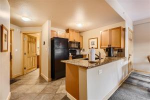 a kitchen with a black refrigerator and a counter at Passage Point 311 Condo in Frisco