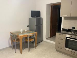 a kitchen with a small table and a refrigerator at Casa Vacanze Le Case in San Gimignano