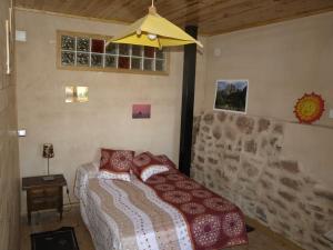 a bedroom with a bed and a stone wall at Casa Rural La Tormenta in Albendiego