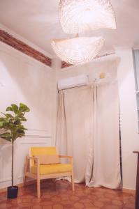 una silla y una maceta en una habitación con una lámpara de araña en El Palomar Alquiler en Posadas