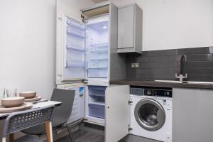 a kitchen with a washer and dryer in it at Modern and Comfy in City Centre PS4 , Free Parking ,Walking Distance To Bus, Train Stations And Shopping Centres in Leicester