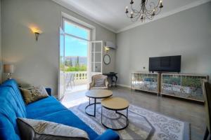 a living room with a blue couch and a table at Luxury 2-floor Flat (95 sqm) near Hotel Martinez in Cannes