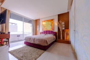 a bedroom with a large bed and a large window at Pasadena Lodge in Pattaya Central
