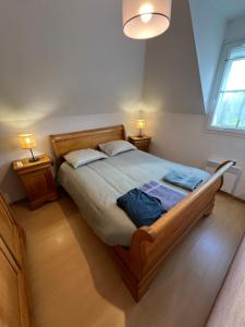 a bedroom with a large wooden bed with two lamps at Maison Ariana 6 personnes à 5 min de la mer in Le Crotoy