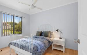 a white bedroom with a bed and a window at Hazel Beach House - Ocean Views & Coastal Charm in Goolwa South +42 photos