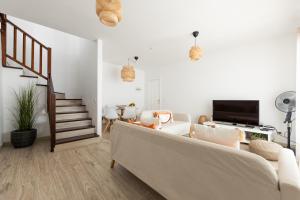 a living room with a couch and a staircase at Casa Moure in Costa Teguise