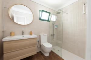 a bathroom with a toilet and a sink and a mirror at Casa Moure in Costa Teguise +7 photos