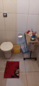 ein Badezimmer mit einem WC, einem Tisch und einem Teppich in der Unterkunft BiaMar in Luminárias