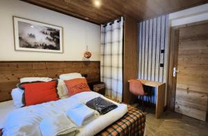 a bedroom with a bed and a chair in it at Chalet Totoro - Chalets pour 14 Personnes 514 in Valloire