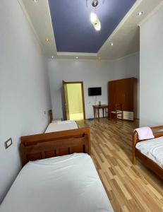 a room with two beds and a tv in it at Haliti hotel in Kukës