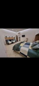 a large bedroom with two beds and a tv at Home Santa Chiara Marigliano in Marigliano