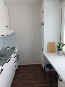 a kitchen with white cabinets and a white counter top at Viihtyisä ja valoisa yksiö keskustan läheisyydessä in Heinola