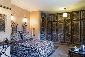 sypialnia z łóżkiem w pokoju z drewnianymi ścianami w obiekcie Riad des 1001 Fleurs w mieście El Arba
