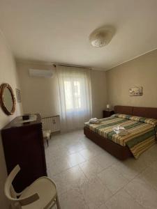 een slaapkamer met een bed, een tafel en een stoel bij Le Stanze della Valle Affitti uso turistico in Agrigento