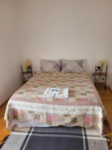 a bedroom with a bed with a quilt on it at Ninho dos Passaros Penedo RJ in Penedo