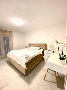 ein weißes Schlafzimmer mit einem Bett und einem Tisch in der Unterkunft Seaview Villa Koper in Koper