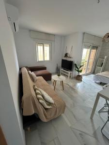 a bedroom with a bed and a living room at Apartamento Ve&Va in Torre del Mar