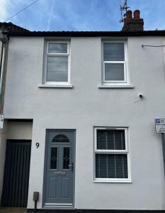 Casa blanca con puerta y ventanas azules en Modern 2 Bed House in Rainham, Kent - Central Location en Rainham