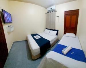 a hotel room with two beds and a tv at Solo Nunes in Manaus