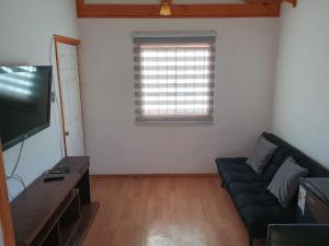 a living room with a couch and a window at CABAÑAS BRUJAS in Salamanca