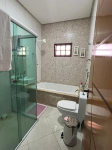 a bathroom with a toilet and a bath tub at Casa Confort in Juazeiro do Norte