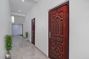 a large wooden door in a room with a hallway at Collection O Cosmos Resort in Rājpur