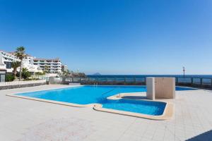 a swimming pool with the ocean in the background at Bungalow Relax Marine in Arona