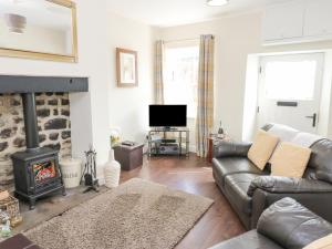 a living room with a couch and a fireplace at 1 Countryman Inn Cottages in Hunton