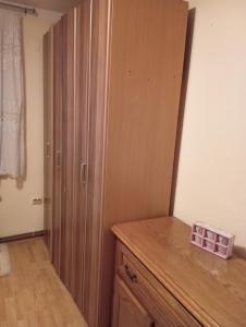um quarto com um armário de madeira, uma cómoda e uma porta em Dženana em Sarajevo