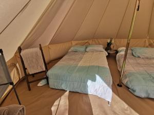 two beds in a tent with a chair at #4 1913 in Drumheller