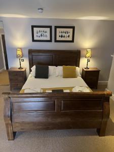 a bedroom with a large wooden bed with two lamps at The George Inn in Hatherleigh