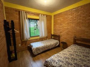 Casa Girassol في كونسيساو  دا إيبيتيبوكا: غرفة نوم بسريرين ونافذة